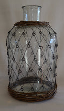 Glass bottle with 'fisherman' metal weave