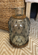 Glass bottle with 'fisherman' metal weave