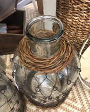 Glass bottle with 'fisherman' metal weave