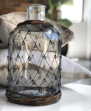 Glass bottle with 'fisherman' metal weave